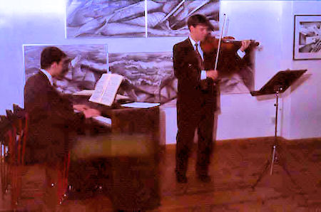 Piano och violin i samklang med tavlor av Bo Johner